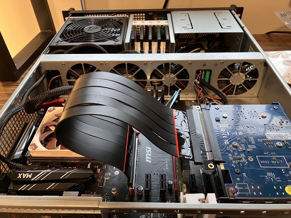 Side view of the server with the lid open. The riser cable protrudes noticeably up