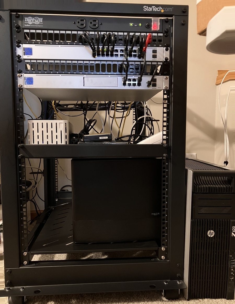 18U StarTech rack with a switch, router, 2 patch panels, and a shelf installed. Next to the rack on the right side is a free-standing HP workstation.