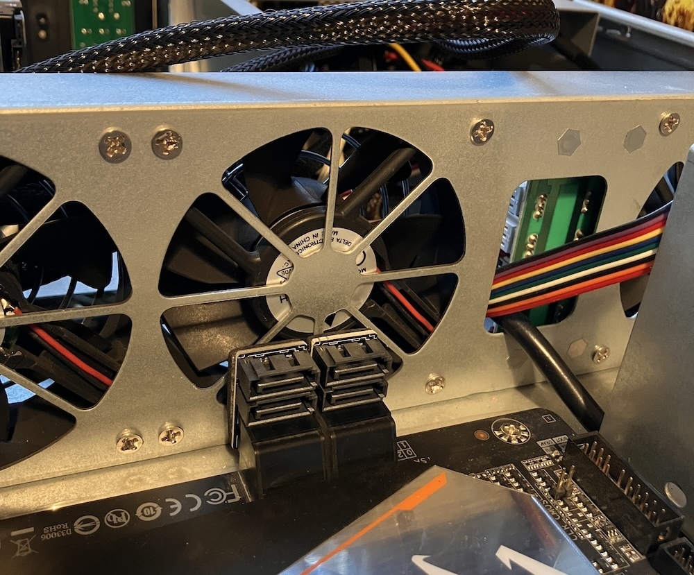 Close-up shot showing 2 180-degree adapters plugged into a block of 4 SATA connects on the motherboard.