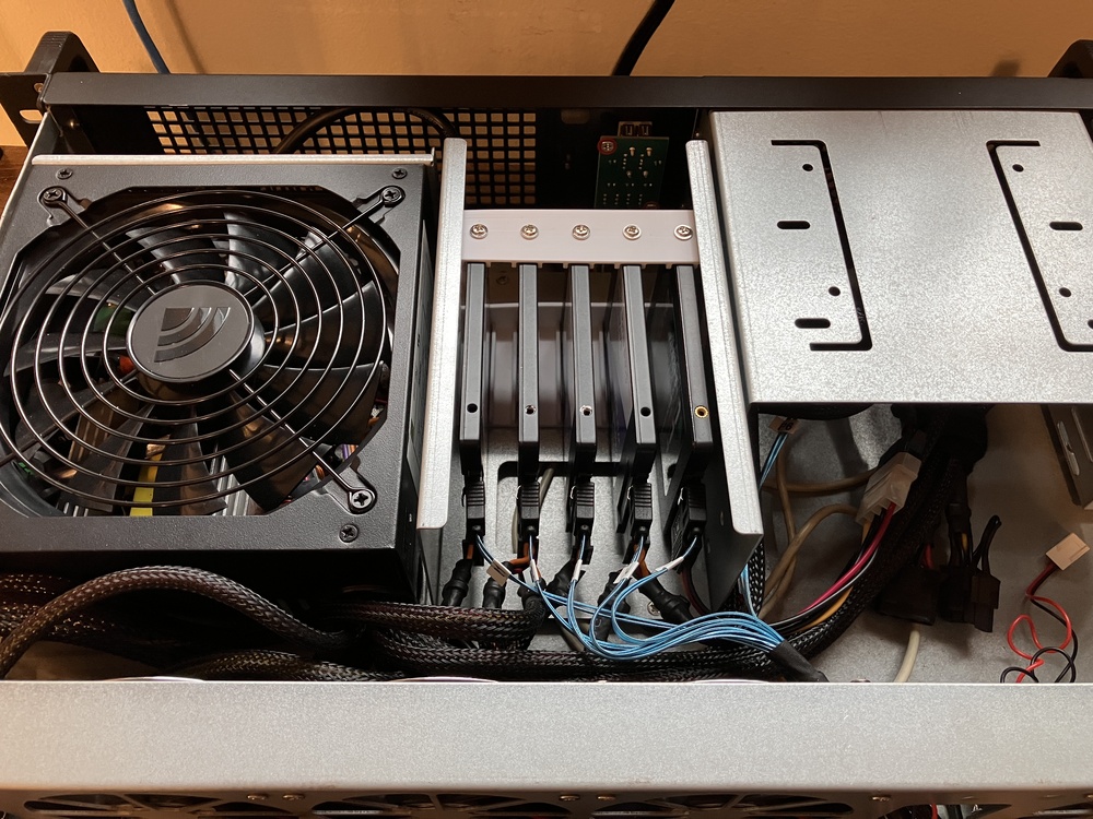 top-down photo of the inside front of the server. The caddy part is installed and 1 SSD is mounted in it.